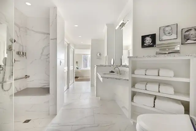 Accessible primary bathroom remodel with a walk-in shower, grab bar, handheld shower, marble-look tile and open towel shelving
