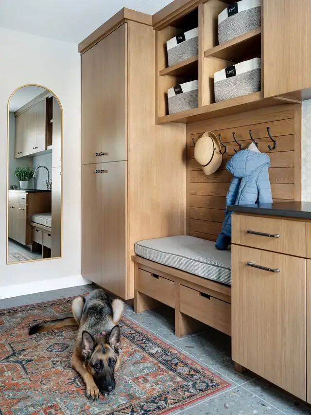 Mudroom with white oak lockers, a cushioned bench, cubby baskets and a patterned rug