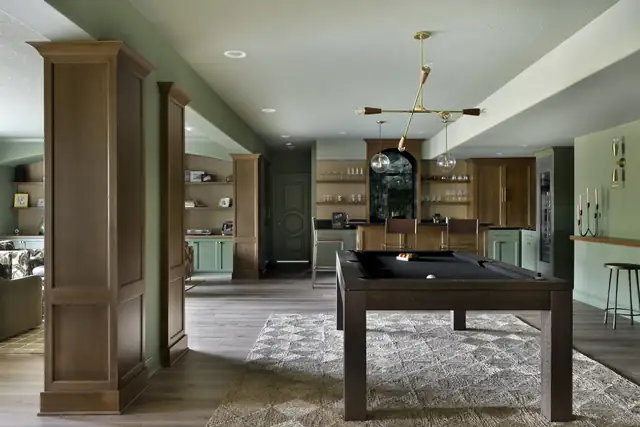 Inver Grove Heights lower level remodel with a billiard table, stained wood columns, sage green walls and built-in shelving