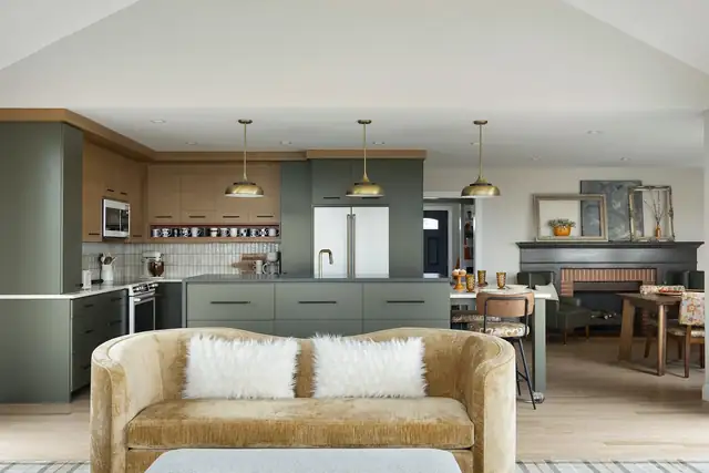 Bloomington kitchen and main floor remodel with sage green and wood cabinets, brass pendants and a gold velvet sofa in the open living area