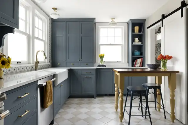 Recrafted kitchen in a 100-year-old St. Paul home with slate blue cabinets, a farmhouse sink, checkerboard tile floor and a wood work table